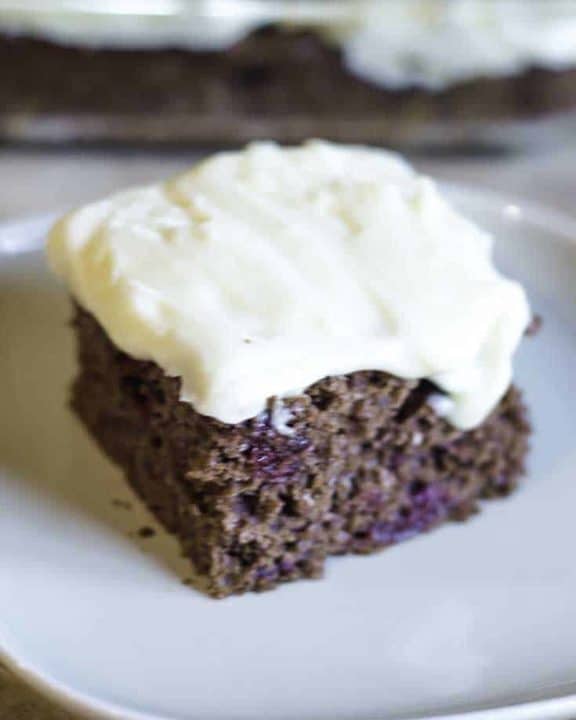 A slice of devil's food cake topped with cream cheese frosting