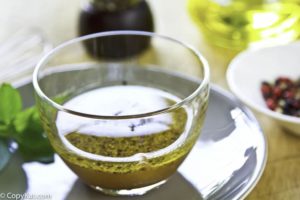 A bowel of homemade vinaigrette. Pepper corns, herbs, and oil help make this salad dressing.