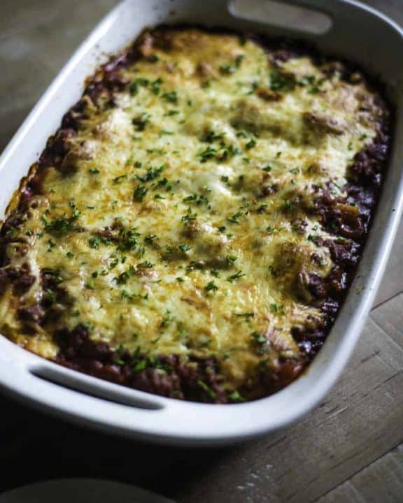 Four Cheese Manicotti with meat sauce topped with cheese in a baking dish