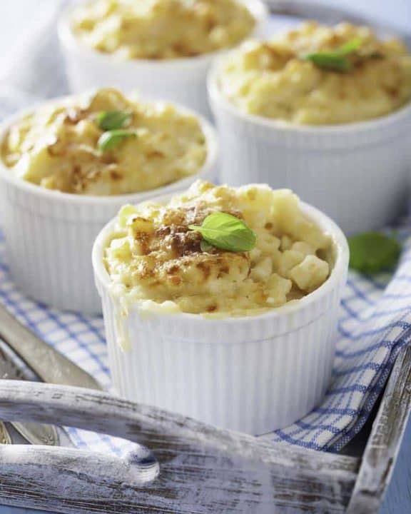 Four individual ramekins of baked macaroni and cheese