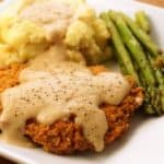 Beer battered chicken fried steak with gravy, mashed potatoes, and asparagus