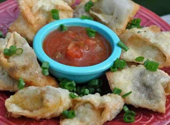 A plate of taco wontons and salsa