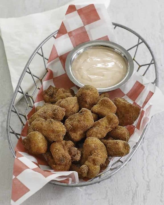 chicken nuggets and dipping sauce in a wire basket