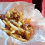 a basket of cheese fondue fries with bacon