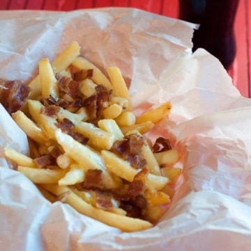 a basket of cheese fondue fries with bacon