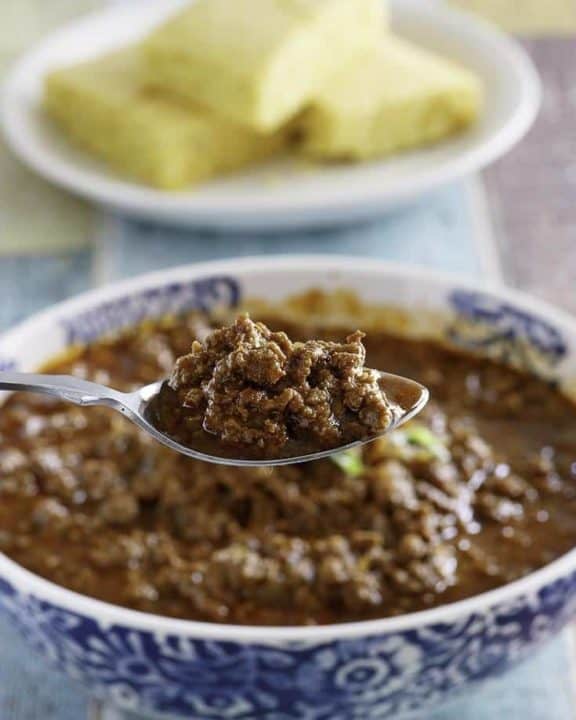 A spoon of copycat Chilis Original style chili over a bowl of it.