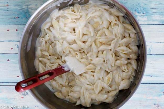 Stirring Panera Bread Macaroni and Cheese in a stainless steel prep bowl. 