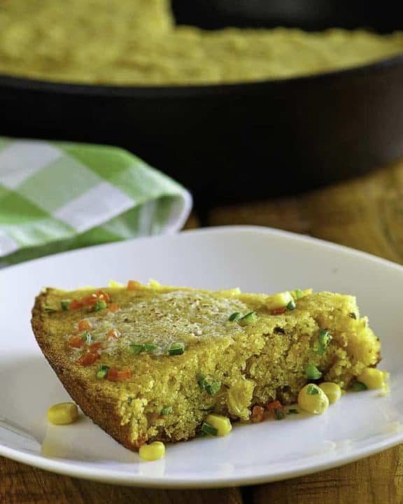 a plate with a slice of jalapeno cornbread with melted butter on top.