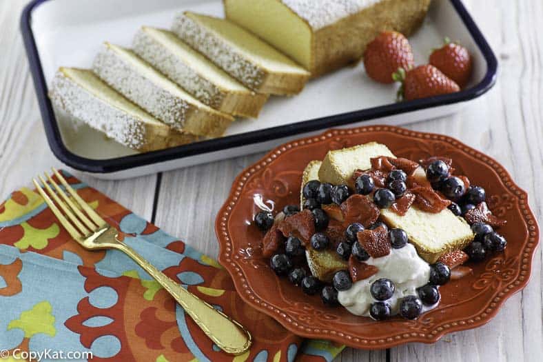 Homemade copycat Sara Lee Pound Cake and fruit on a red plate.