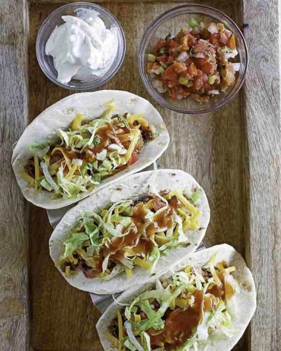 3 tacos with homemade Taco Bell taco sauce drizzled on top.