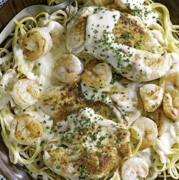 Homemade copycat Outback Steakhouse Queensland Chicken and Shrimp Pasta and fork in a brown wood bowl.