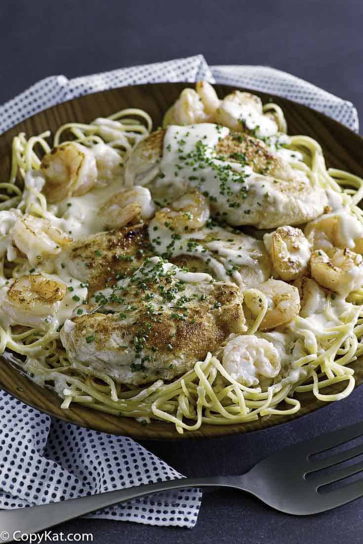 Homemade copycat Outback Steakhouse Chicken and Shrimp Pasta in a brown bowl.
