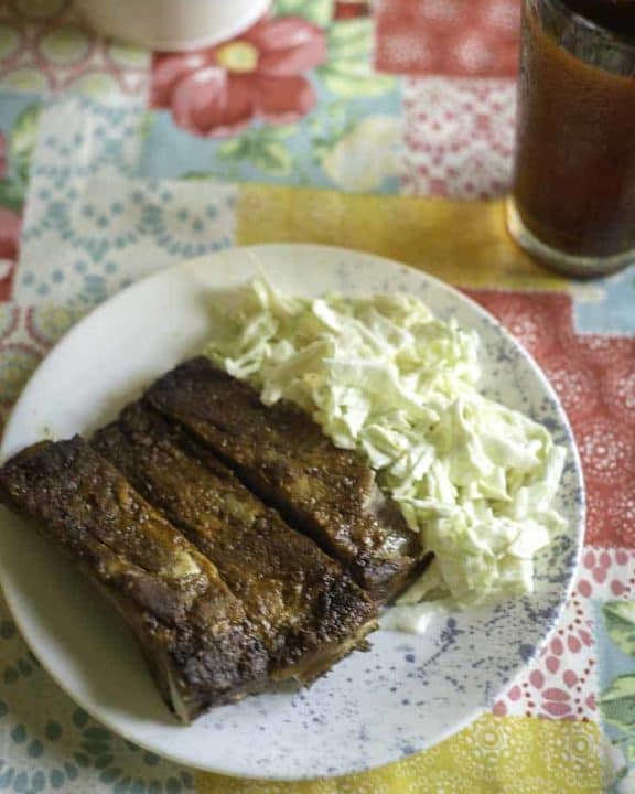 A plate of ribs and homemade coleslaw made with heavy cream, vinegar, and sugar