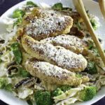 Parmesan crusted chicken tenders and pasta on a plate.