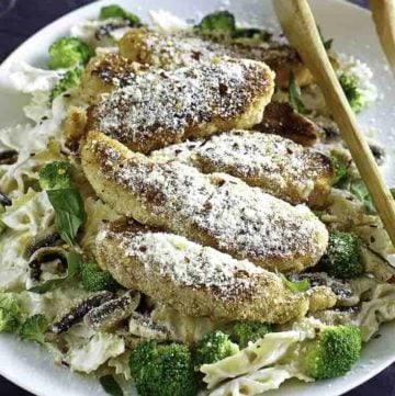Parmesan crusted chicken tenders and pasta on a plate.
