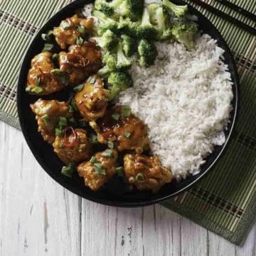 A plate of General Tso's chicken with rice and broccoli.