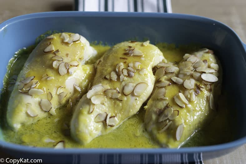 A baking dish with three oven baked lemon sunshine chicken breasts. 