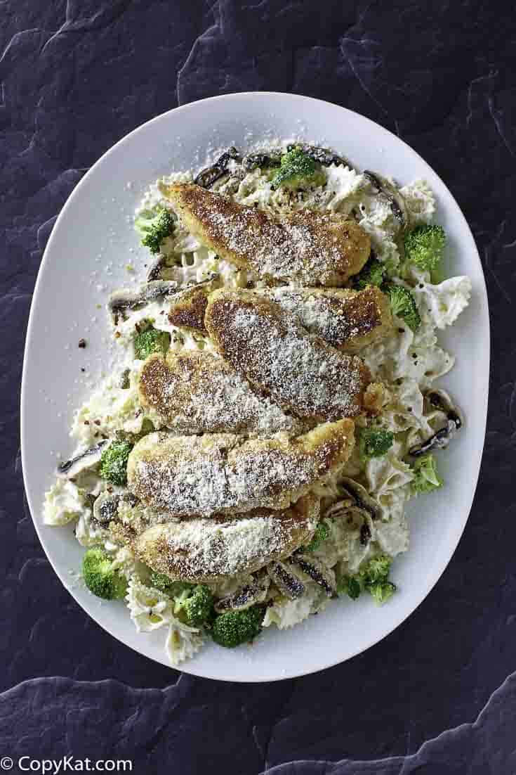 A platter of parmesan crusted chicken tenders and pasta