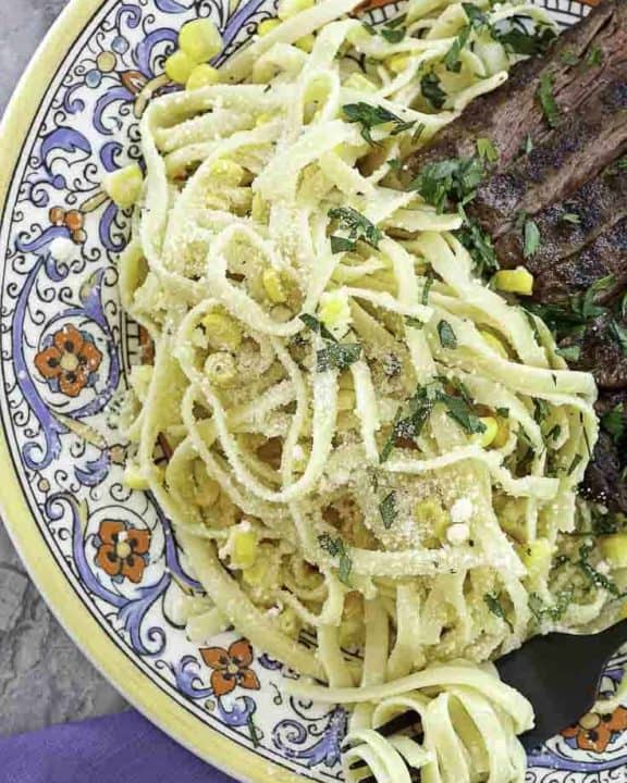 fettuccine pasta salad and steak on a plate