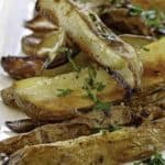 a plate of roasted potatoes with herbs