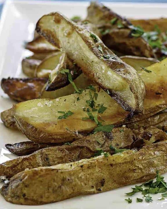 a plate of roasted potatoes with herbs