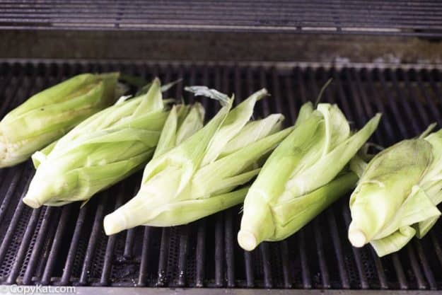 fresh corn being grilled on a hot grill