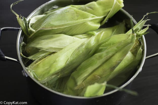 Fresh corn with the silks removed soaking in water 