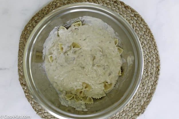 mixing up a tuna noodle casserole in a bowl before baking