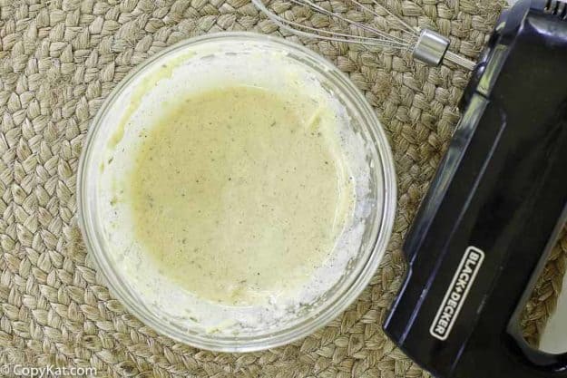 using a mixer to prepare homemade caesar salad dressing