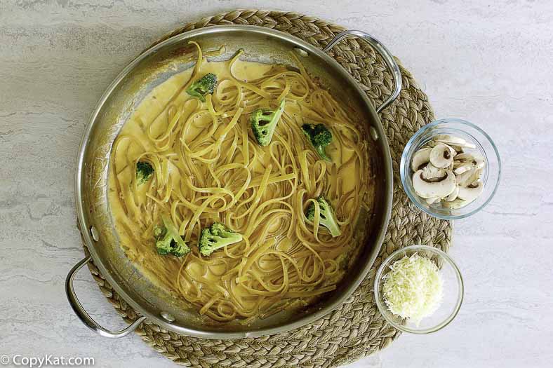 a skillet of pasta with alfredo sauce