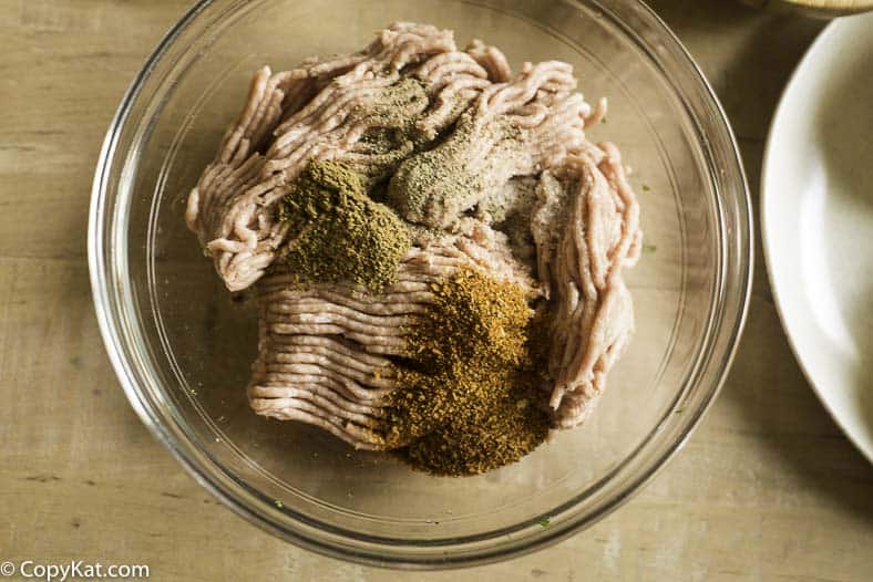 adding seasonings to the ground meat