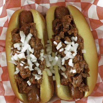chili con carne on top of hot dogs