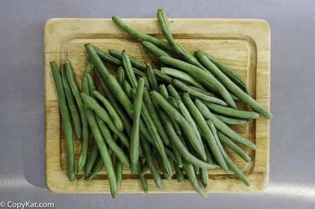fresh green beans on a wood cutting board
