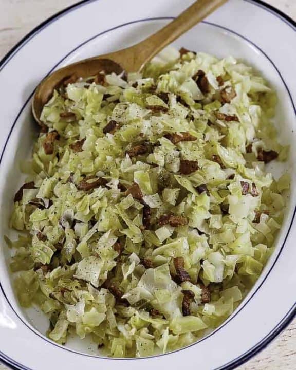 a plate of boiled cabbage with bacon