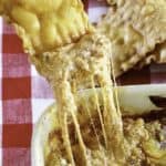 a pasta chip dipping into cheesy lasagna dip