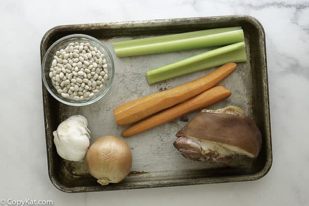 Ingredients for navy bean soup, navy beans, onions, ham hock and more