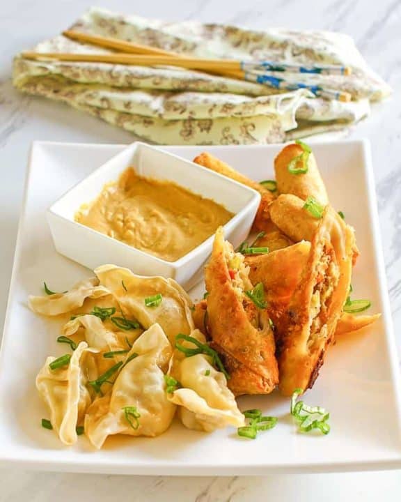 Chinese hot mustard, dumplings, and egg rolls on a platter