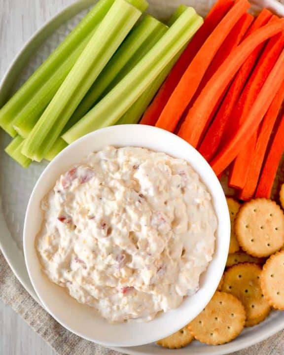 old fashioned pimento cheese spread on a platter with celery, carrots, and crackers