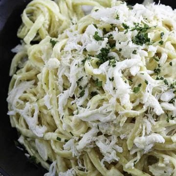 A plate of alfredo pasta with crab