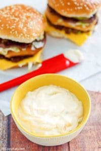 homemade Big Mac special sauce in a small bowl and two homemade Big Mac burgers