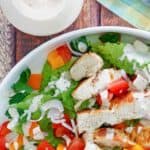 creamy pesto dressing next to a grilled chicken salad
