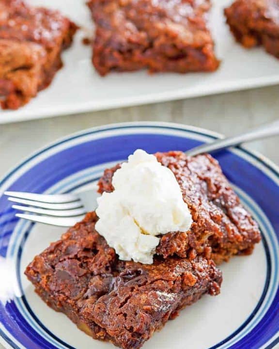 two slices of chocolate pudding cake topped with whipped cream