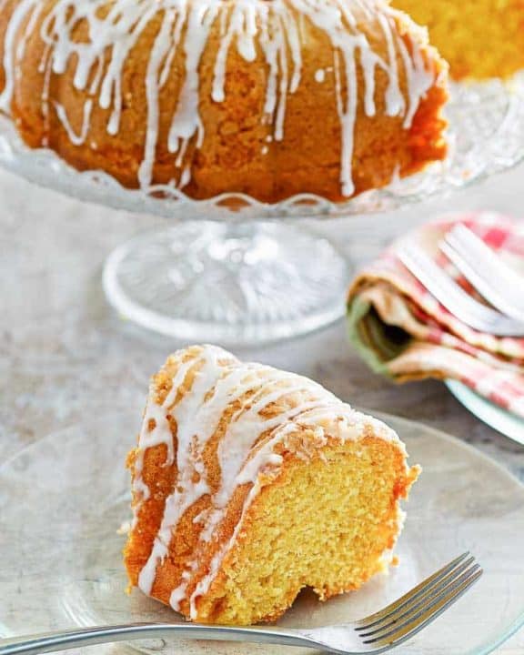a slice of golden pound cake in front of the cake