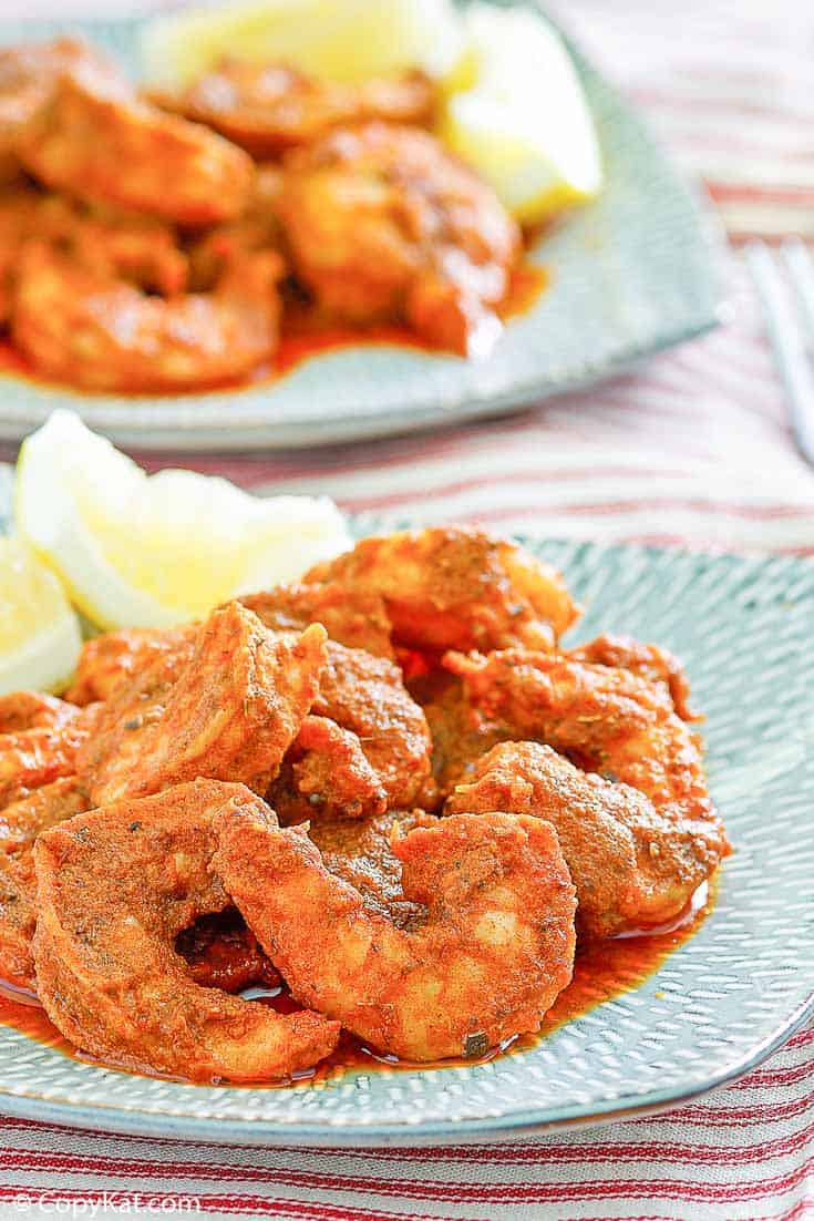 Homemade Red Lobster Cajun Shrimp and lemon wedges on a blue plate