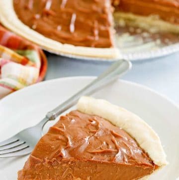 a slice of chocolate cream pie and a fork on a plate