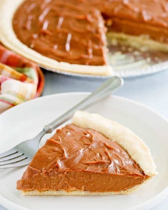 a slice of chocolate cream pie and a fork on a plate