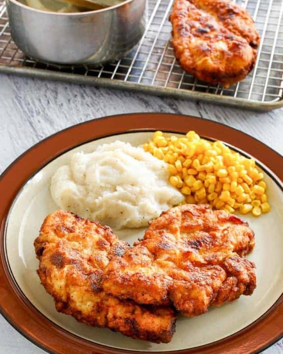 homestyle fried chicken, mashed potatoes, and corn on a plate