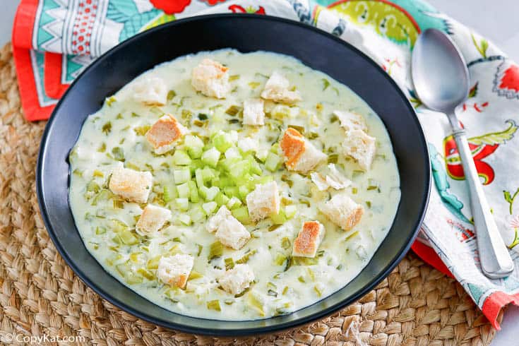 a bowl of homemade cream of celery soup in a black bowl