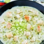 a bowl of cream of celery soup topped with croutons