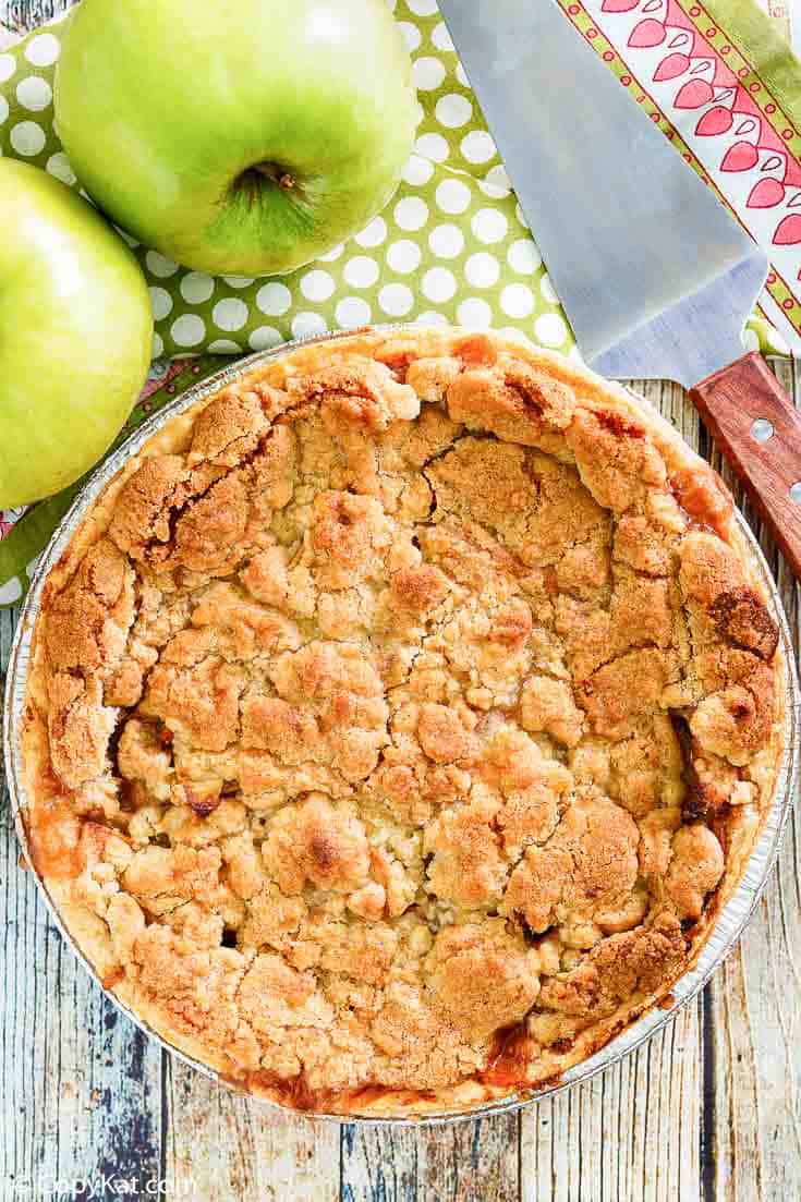 a whole Dutch apple pie, green apples, and a pie server